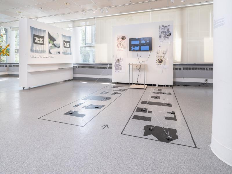 installation image of multiple design works on the floor and walls in a gallery