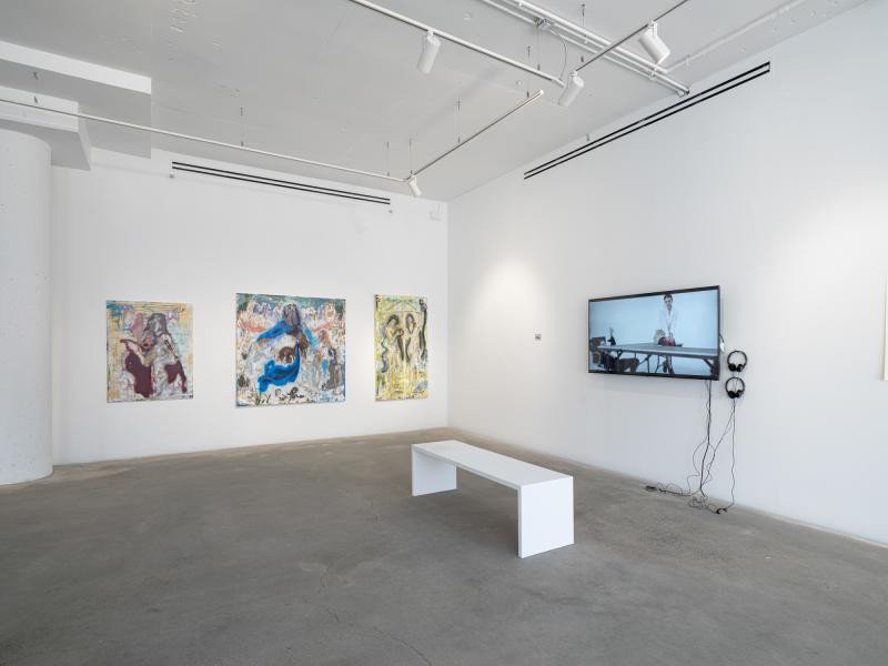installation image of three wall mounted paintings and a wall mounted monitor