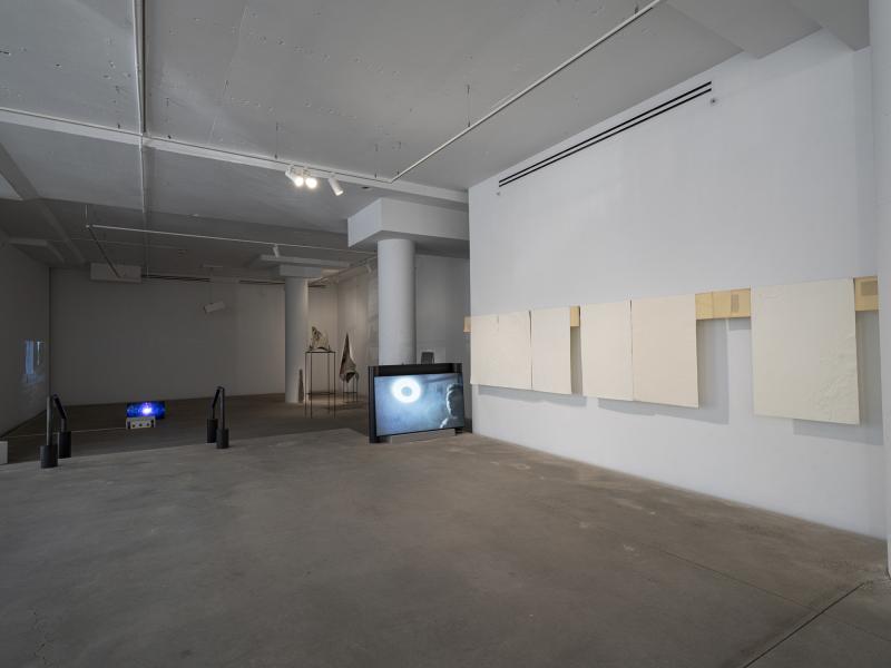 installation image of prints, floor monitor, and sculptures