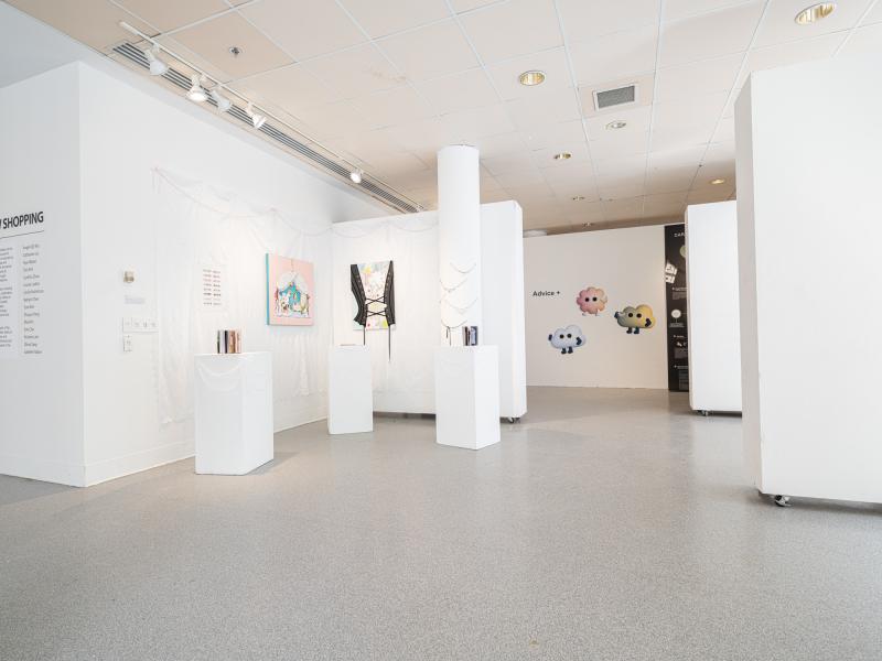 installation image of multiple paintings and design works in a gallery