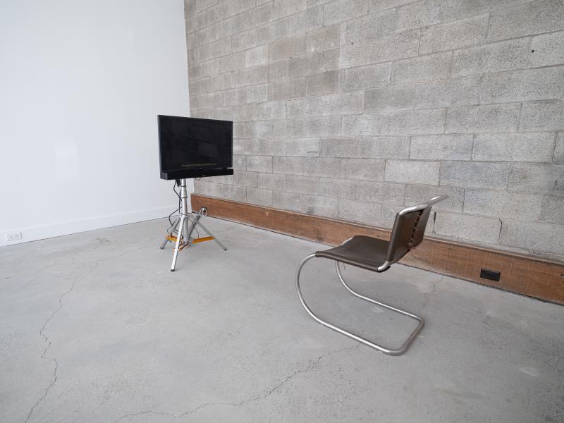 installation image of a leather chair facing a monitor on a floor stand