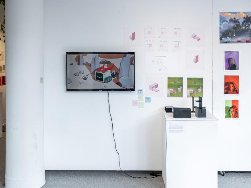wall installation with monitor displaying an animation as well as drawings and diagrams 
