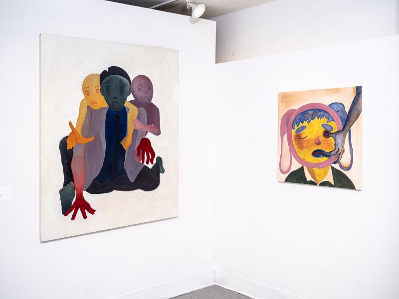two figurative paintings installed in a corner of the gallery