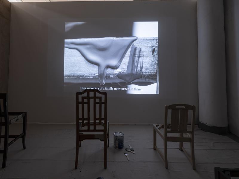 video projection with several painted chairs installation