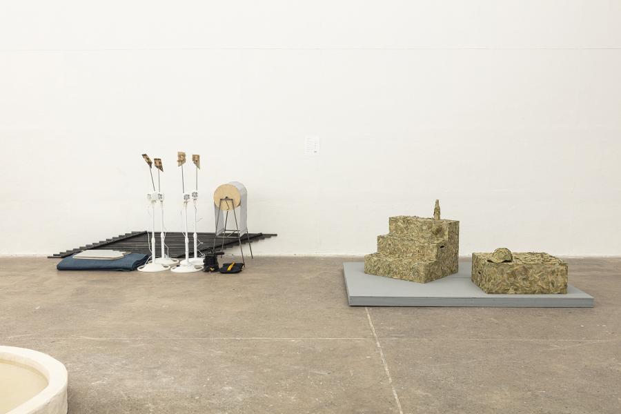 Image of floor sculptures including a stage with props on the right and various other props on the left