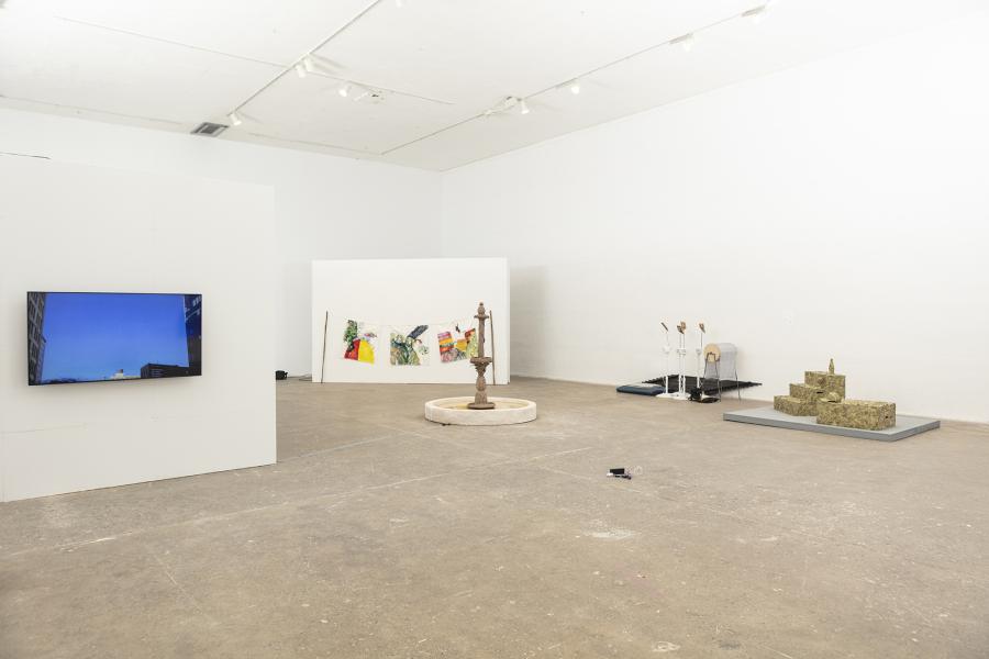 installation image of multiple sculptures, video monitor, and paintings