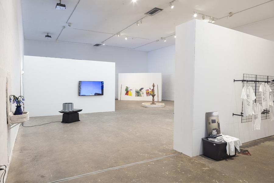 installation image of multiple pieces including wall sculptures, video pieces, and paintings