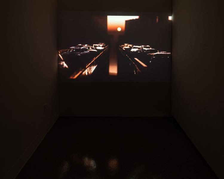 projected video artwork in a darkened gallery space