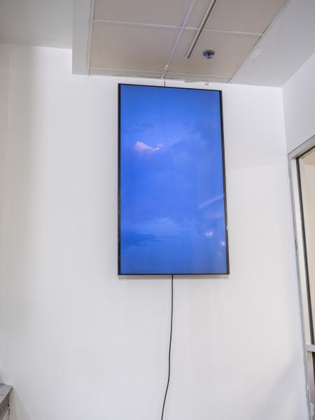 video screen installed near the ceiling on a gallery wall