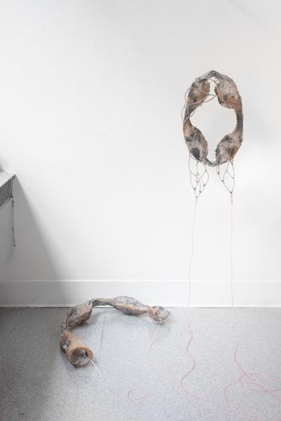 mixed media sculpture installed on a gallery floor and wall