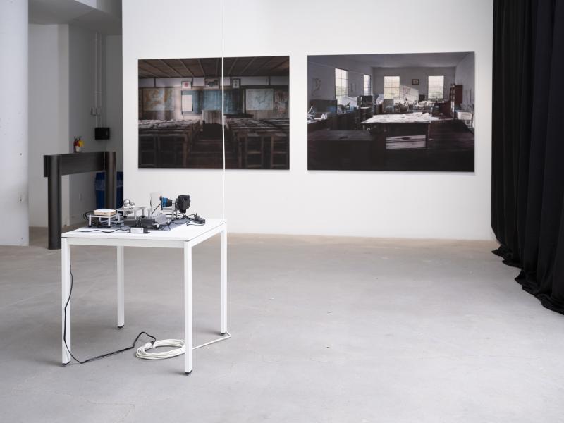 installation image of two large scale photographs and a floor sculpture