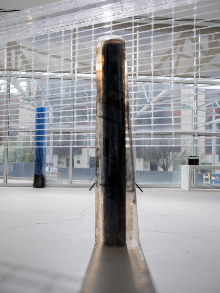 detail of multiple freestanding floor sculptures and a large ceiling hung sculpture in a gallery