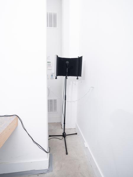 installation image of a microphone on a stand in a gallery