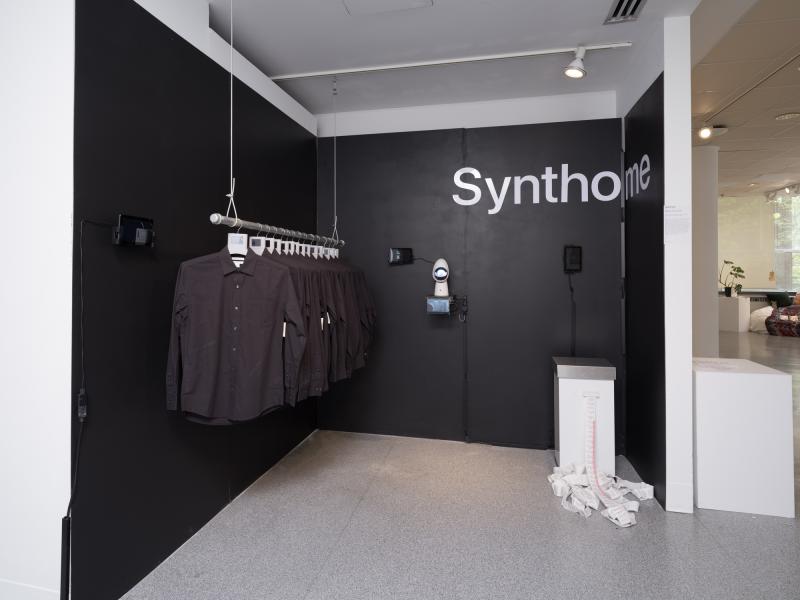installation image of multiple shirts on hangers, graphics, and floor objects
