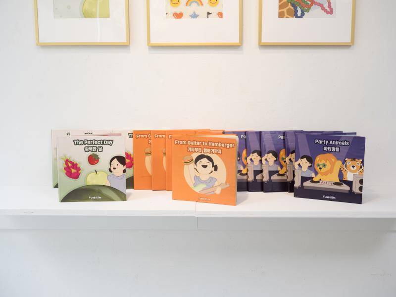 detail image of books on a shelf and framed posters above