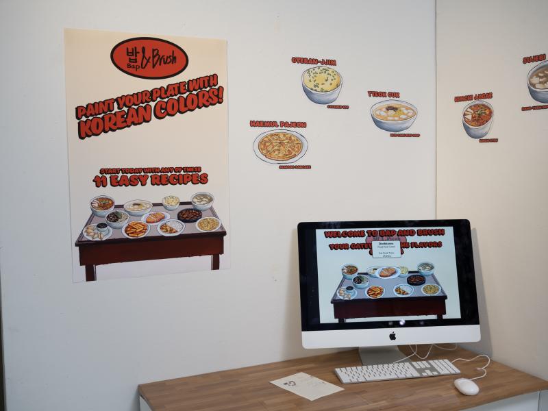 detail image of multiple graphics on a wall and a desktop computer