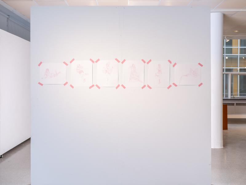 multiple small drawings installed on a gallery wall 