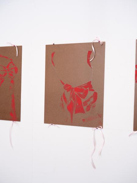 detail image of mixed media paintings installed in a row on a gallery wall 