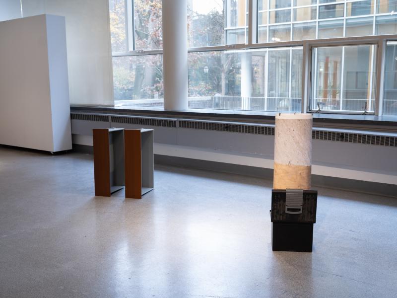two mixed media sculptures installed on the floor of a gallery
