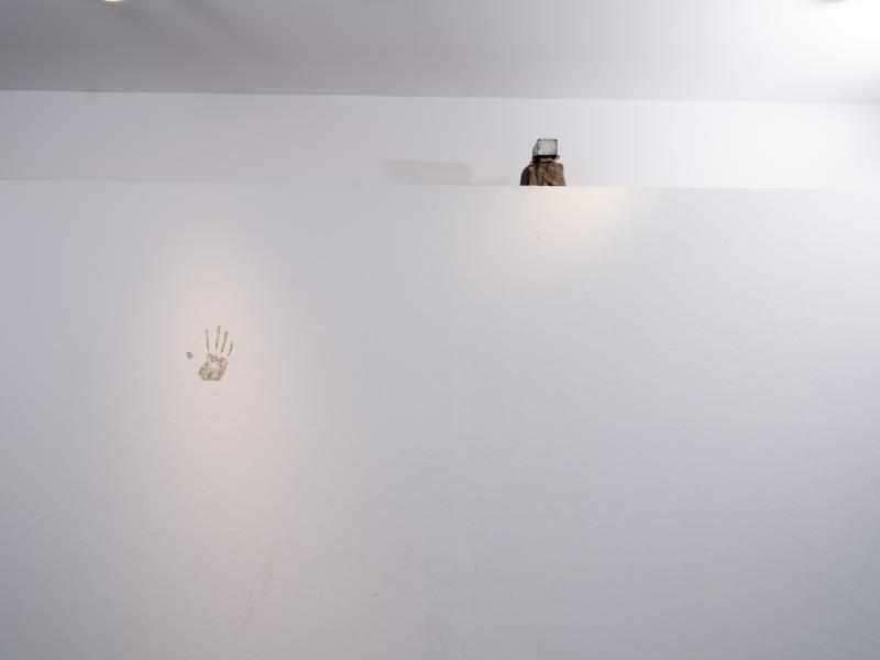 two small mixed media pieces installed on the wall and shelf of a gallery