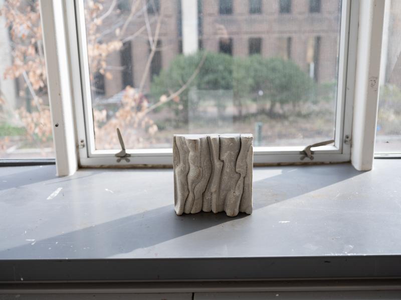 small sculpture installed on a gallery window sill