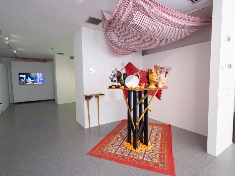 mixed media installation installed in a corner and hanging from the ceiling of a gallery