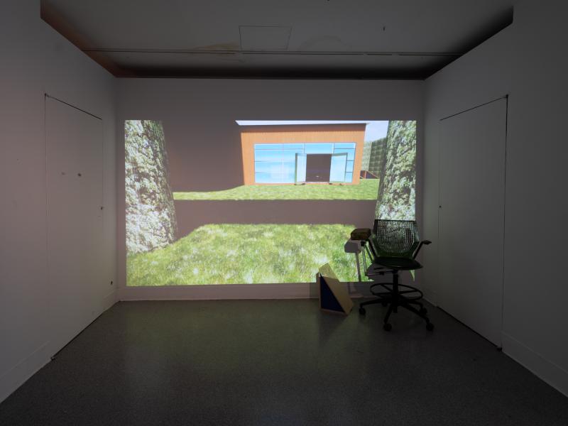 digital projection and chair installed in a dark gallery space