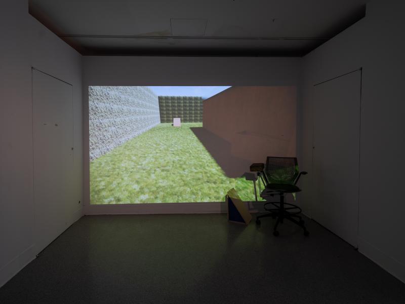 digital projection and chair installed in a dark gallery space