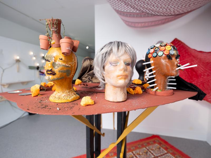 detail image of mixed media sculptures installed on a high table in a gallery