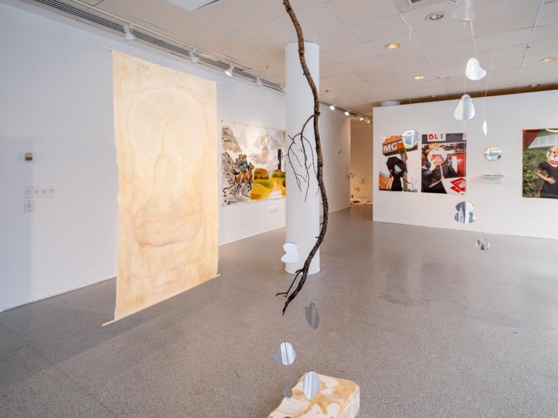 installation view of a mixed media piece installed on the floor and hung from the gallery ceiling
