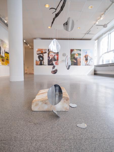 detail view of a mixed media piece installed on the floor and hung from the gallery ceiling