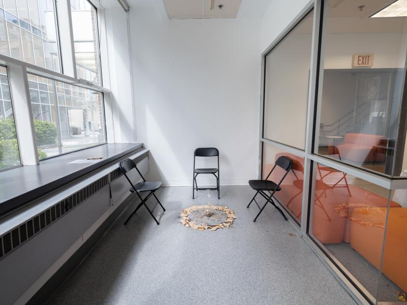 installation image of a mixed media floor installation and surrounding chairs