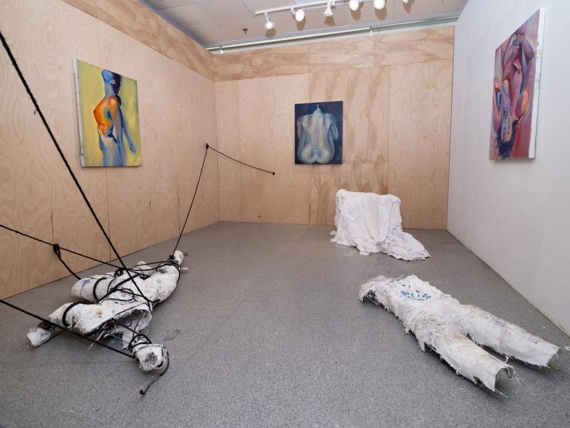 installation of multiple mixed media floor pieces and paintings