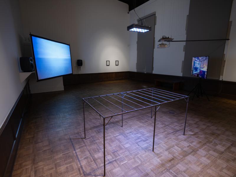 installation image with multiple sculptures, mixed media pieces, and digital video