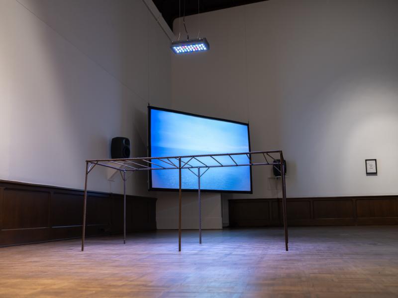 installation image with multiple sculptures, mixed media pieces, and digital video