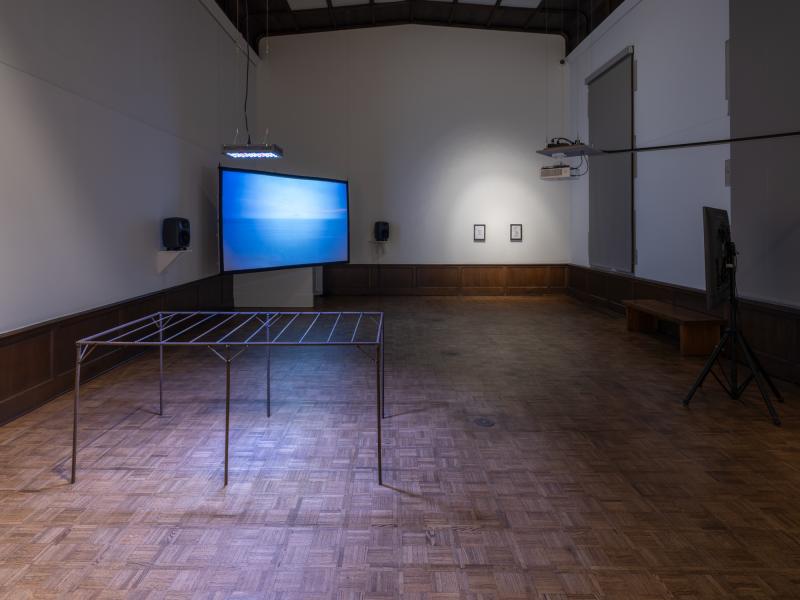 installation image with multiple sculptures, mixed media pieces, and digital video