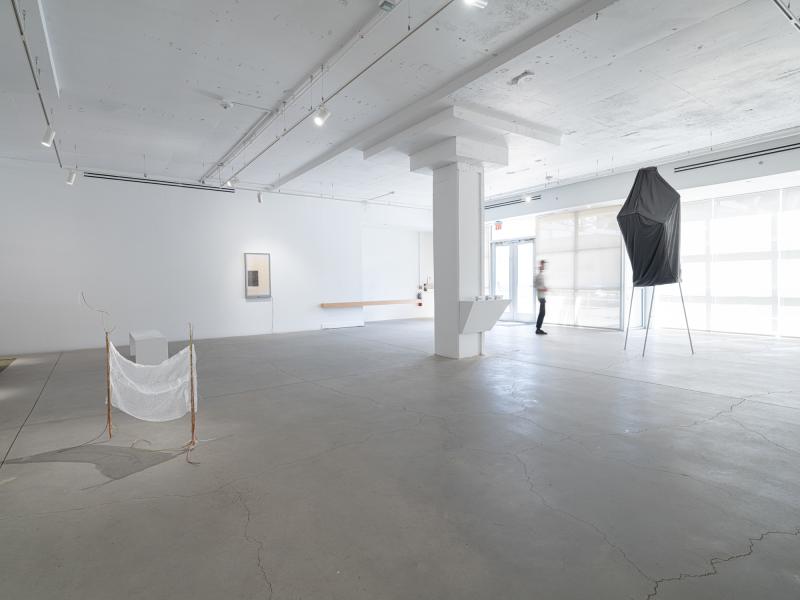 installation image with small floor sculpture, light box, and large floor sculpture