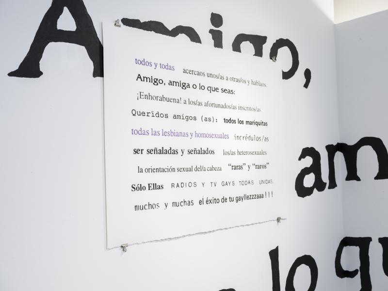 installation displaying painted wall text and poster