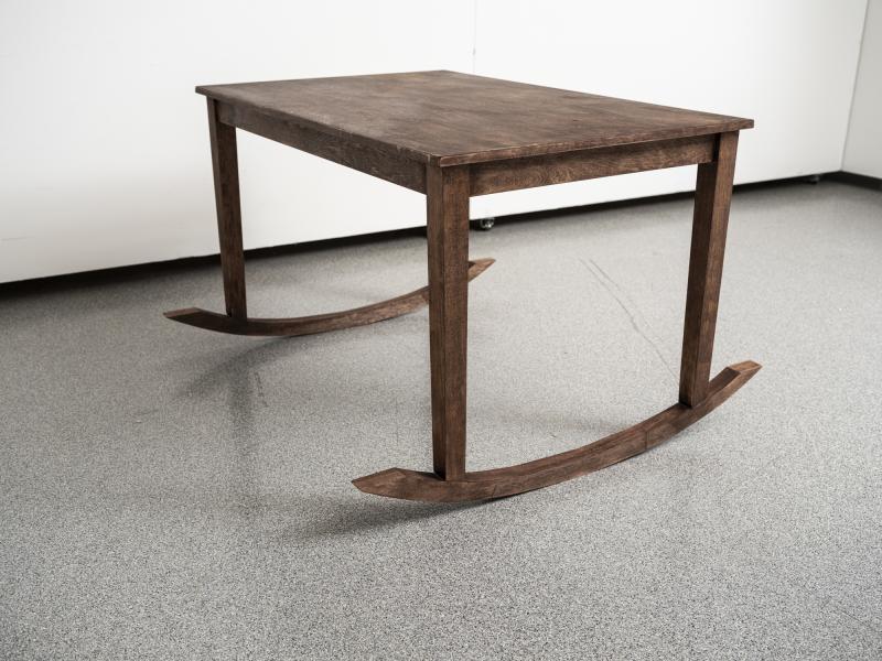 floor sculpture resembling a wooden table and rocking chair combined