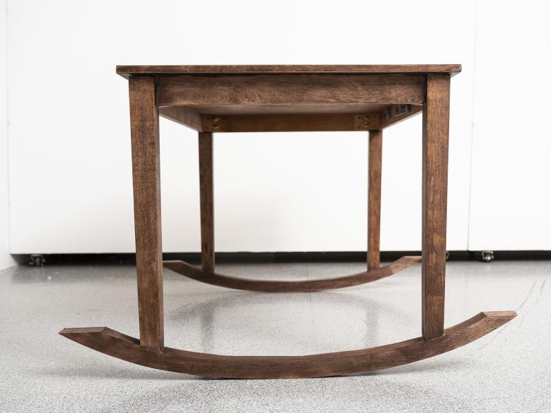 floor sculpture resembling a wooden table and rocking chair combined