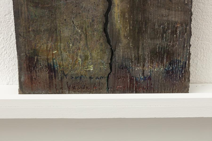 detail image of a darkly glazed ceramic piece on a shelf mounted to the wall