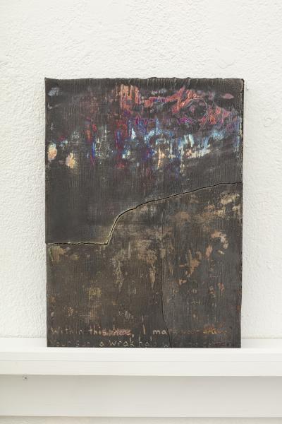 image of a darkly glazed ceramic piece on a shelf mounted to the wall