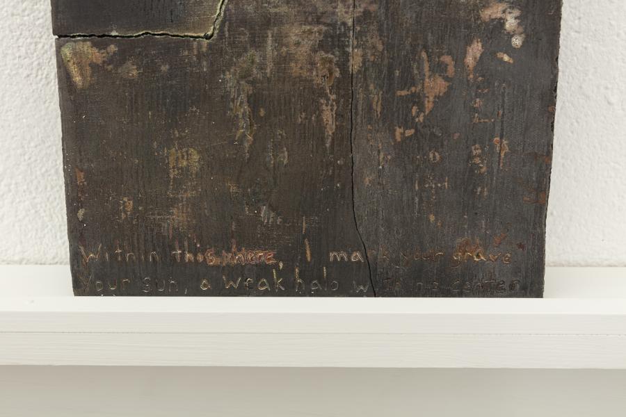 detail image of a darkly glazed ceramic piece on a shelf mounted to the wall