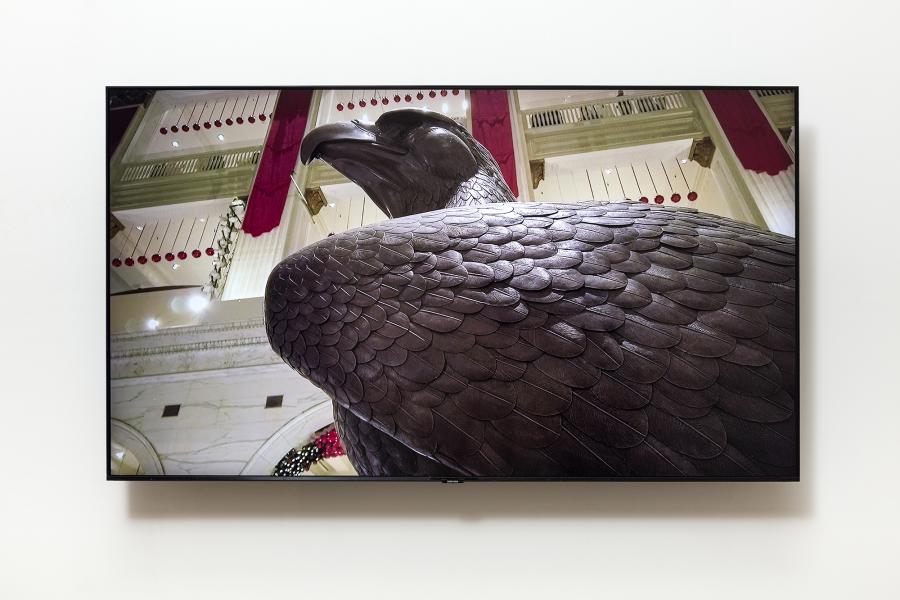 image of monitor displaying a grand interior space and a large bronze eagle sculpture