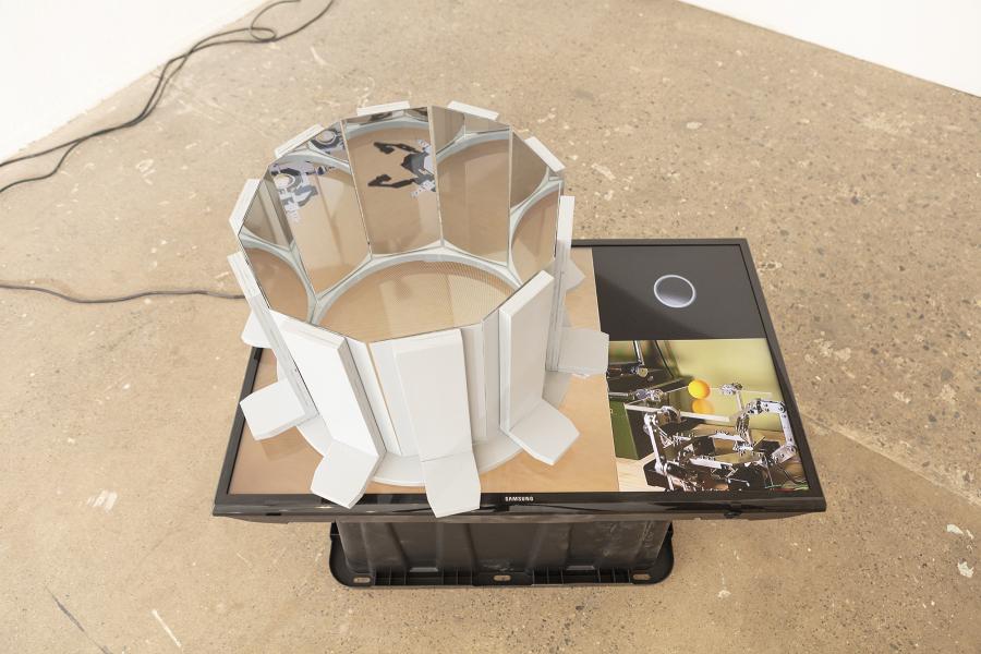 image of a floor sculpture with monitor, mirrors, and plastic bin
