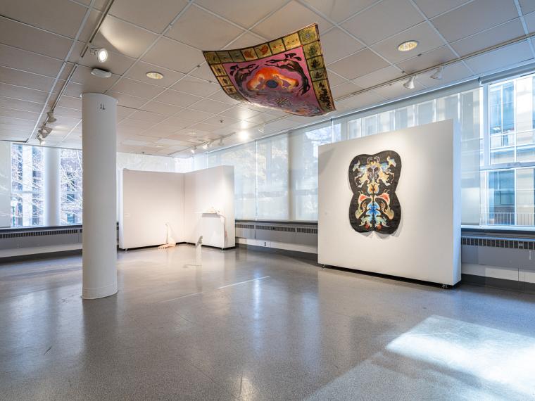 installation image of a painting hanging from the ceiling, painting on a wall and multiple sculptures