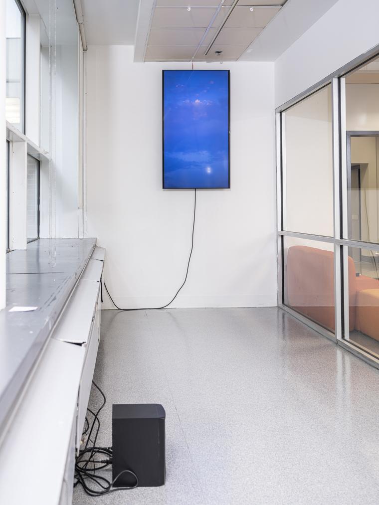 image of a speaker installed on the floor and a video monitor hanging from a gallery wall