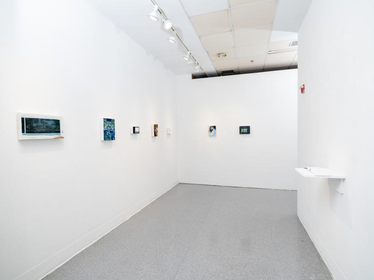 multiple paintings installed on the walls of a gallery