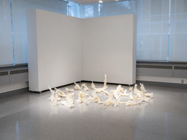 multiple small sculptural object installed on a gallery floor