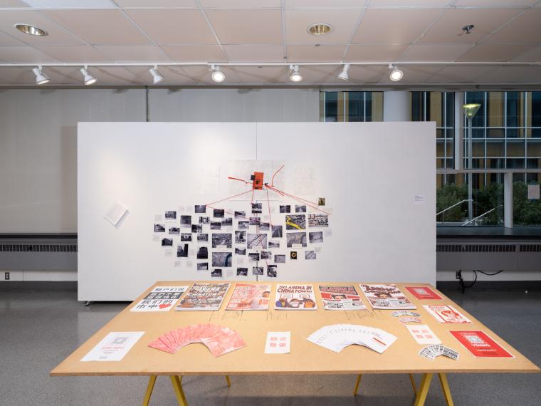 installation of multiple photographs and brochures on a table